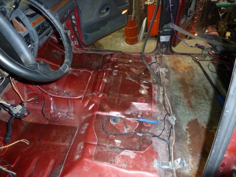 1993 Ford C-150 (Centurion Conversions) - The interior floor of a vehicle shows exposed wiring, rust, and missing carpeting.