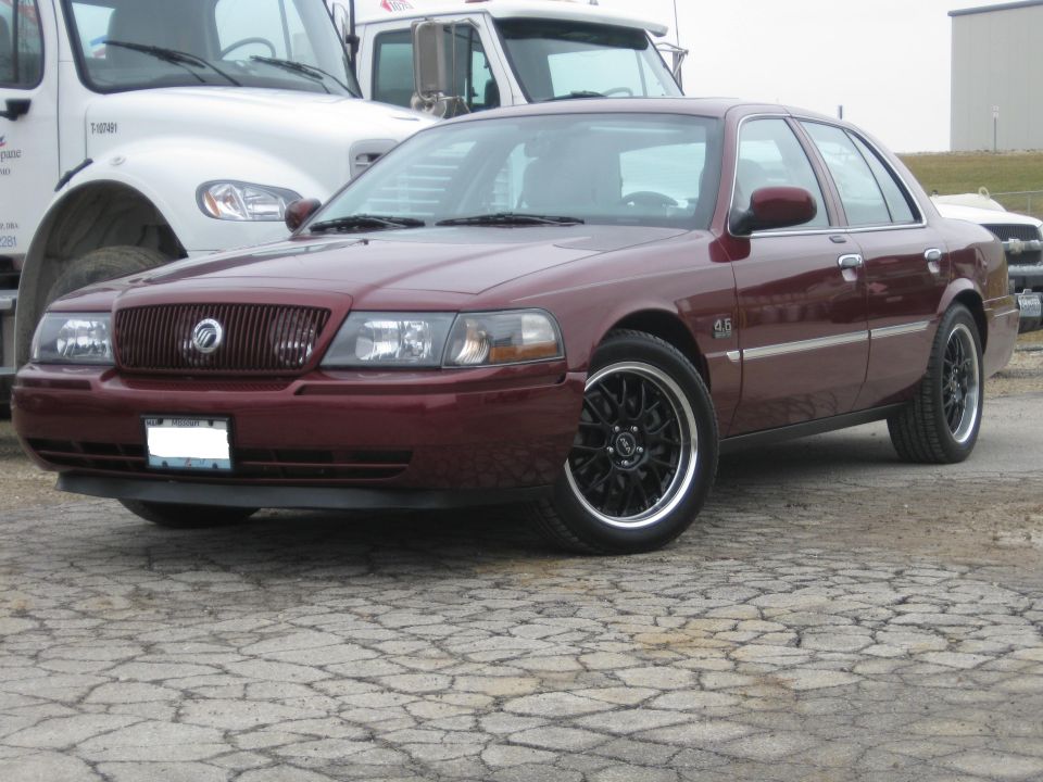 Maroon Mercury Grand Marquis, three-quarter front view on black aftermarket wheels