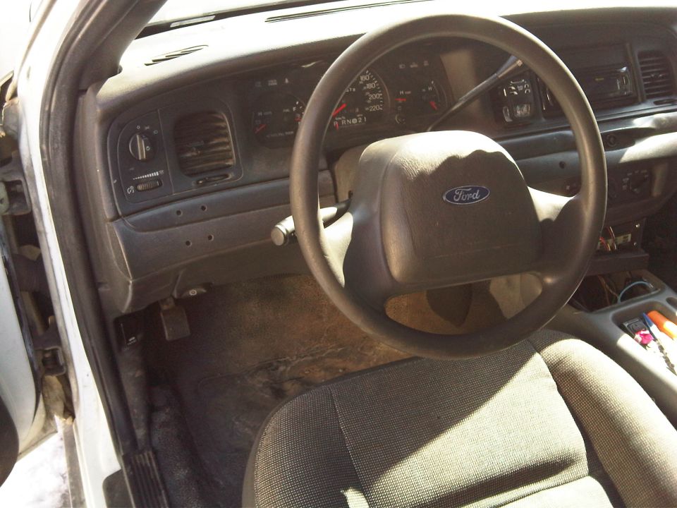 2003 Ford Crown Victoria interior showing dashboard, steering wheel with Ford logo, and driver's seat