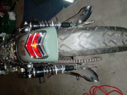 Overhead view of mint green motorcycle rear fender with chevron taillight