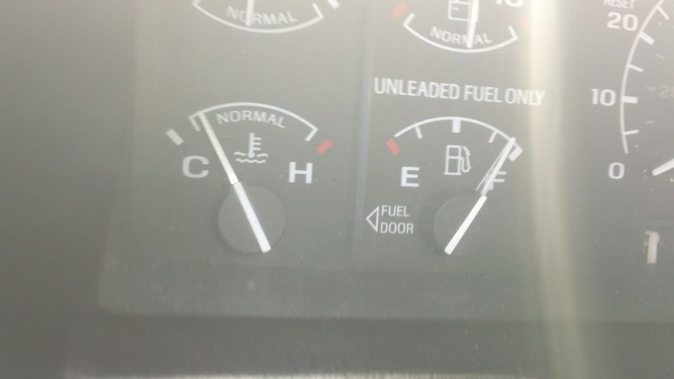 Dash gauges close-up: temperature needle near cold, fuel gauge on full, UNLEADED FUEL ONLY label