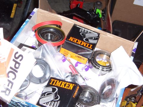1992 Ford Bronco - A collection of automotive bearings and seals, including Timken and Spicer brands, are shown in a cardboard box.