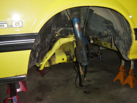 1979 Ford Mustang - Front wheel well of a yellow 1979 Ford Mustang, showing suspension components and a 5.0 badge.