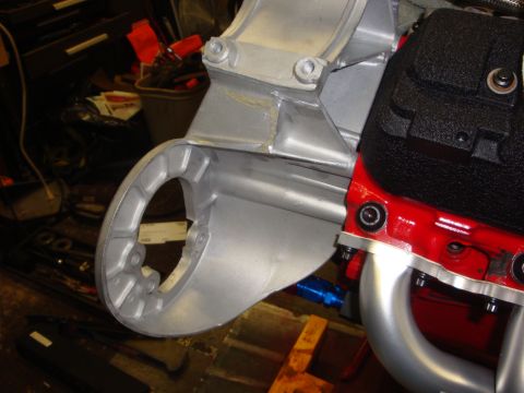 1989 Ford Bronco - A silver bracket is attached to a red engine block, showing part of the engine assembly.