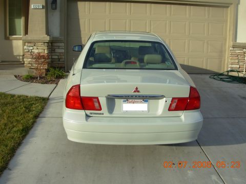 1999 Mitsubishi Diamante - A white sedan is parked in a driveway in front of a closed garage door.