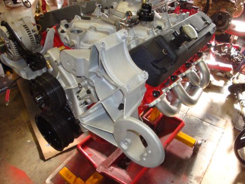 1989 Ford Bronco - Close-up view of a V8 engine assembly, polished headers and a silver intake manifold.