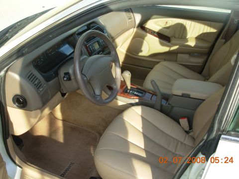 1999 Mitsubishi Diamante - The interior of a 1999 Mitsubishi Diamante features tan leather seats, a wood-trimmed center console, and a tan dashboard.