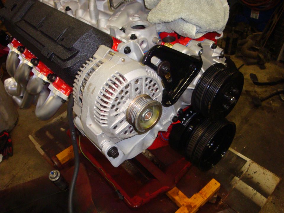 Engine block with silver alternator and black pulleys