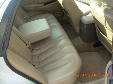 1999 Mitsubishi Diamante - The interior of a car shows tan leather seats and a center console with a built-in armrest.