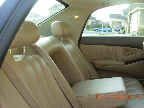 1999 Mitsubishi Diamante - Interior view of a car showing tan leather seats and a glimpse of the exterior through the window.
