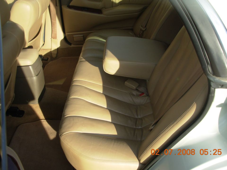 Tan leather car interior with rear seats, armrest, and center console visible. Date stamp reads 02.07.2008