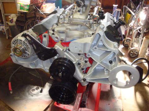 1989 Ford Bronco - Ford V8 engine block assembly with alternator and pulleys, mounted on a red engine stand.