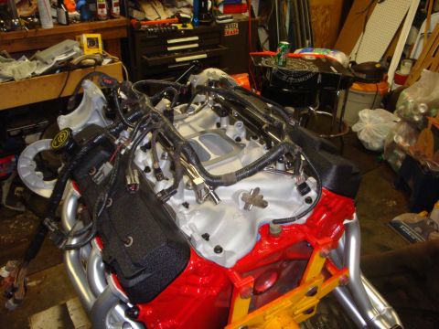 1989 Ford Bronco - Close-up of a rebuilt engine assembly with various components and wiring. The engine is in a workshop setting.
