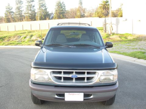 1997 Ford Explorer - The front grille and headlights of a 1997 Ford Explorer are visible, along with a California license plate.