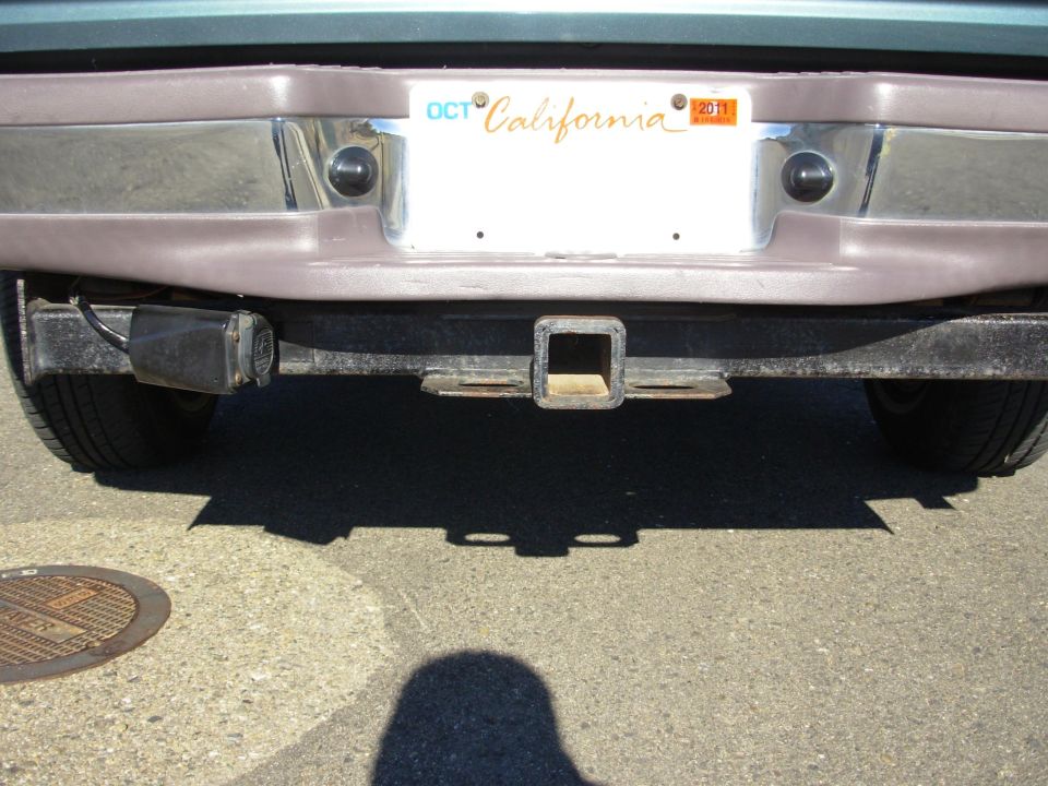 Rear view of a vehicle with a chrome bumper, trailer hitch, and California license plate