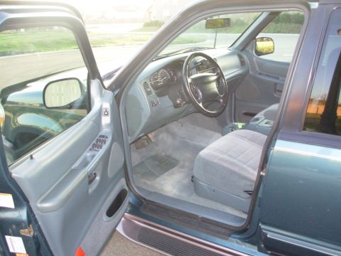 1997 Ford Explorer - The interior of a 1997 Ford Explorer, a gray cloth seat and dashboard with visible gauges.
