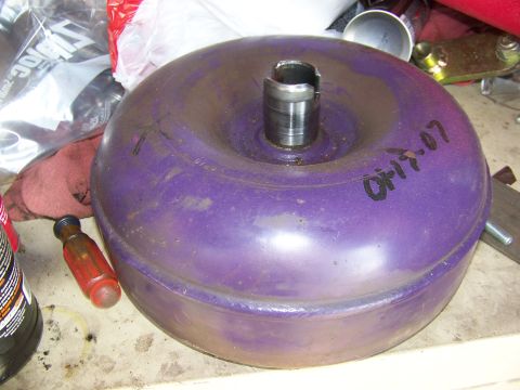 1992 Jeep YJ - A purple torque converter sits on a workbench with tools and other parts in the background.