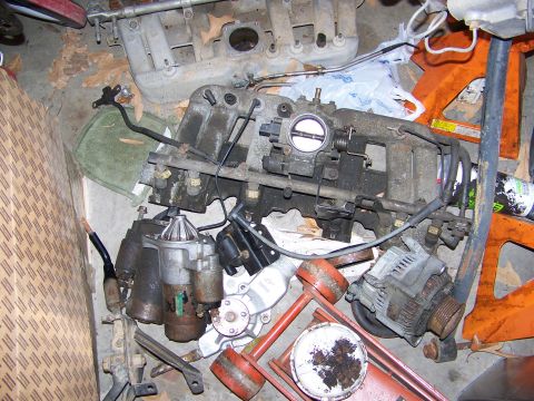 1992 Jeep YJ - Collection of automotive engine parts, including starters and an alternator, are visible in the image.