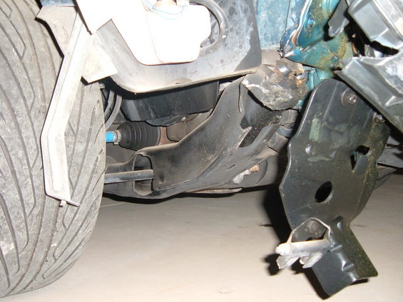 close-up of damaged car front suspension, tire visible