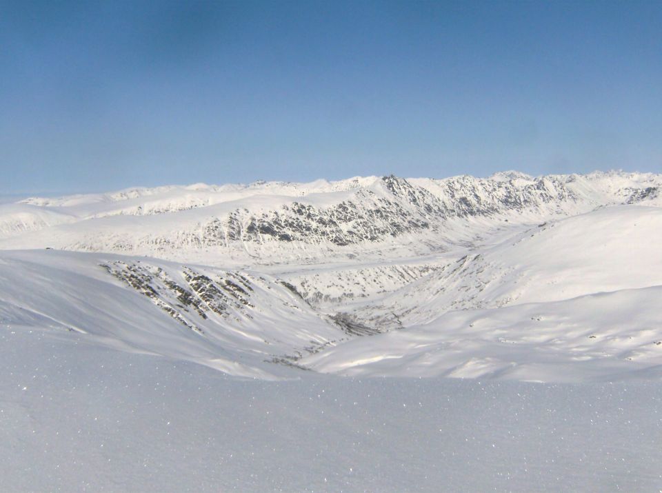 Snowy mountain valley with a clear blue sky