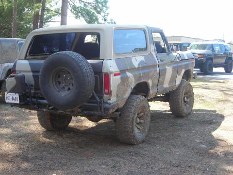 1995 Ford Bronco - This camouflaged SUV features a rear-mounted spare tire and a visible license plate.