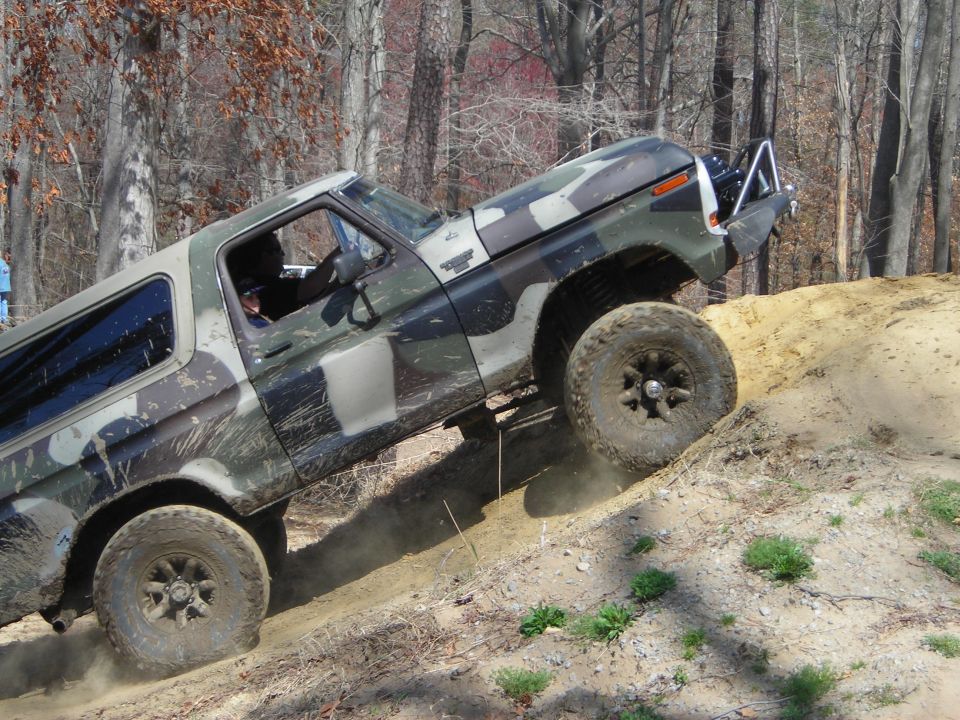 Camouflage Ford Bronco climbing dirt hill