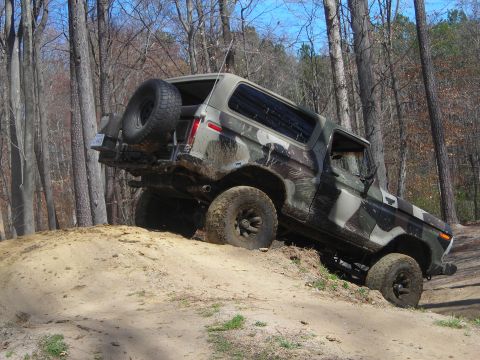 1995 Ford Bronco - Ford Bronco with camouflage paint job navigates an off-road trail.