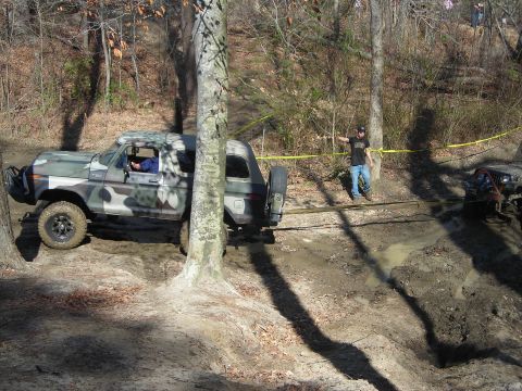 1995 Ford Bronco - A camouflaged 1978 Ford Bronco is being towed through a muddy off-road course.