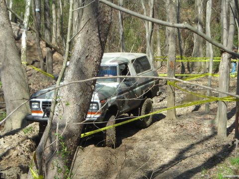 1995 Ford Bronco - This classic Ford Bronco is tackling a challenging off-road course in a wooded area.