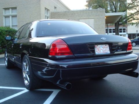 2004 Ford Crown Victoria - Rear view of a black 2004 Ford Crown Victoria showing its distinctive taillights and dual exhaust.