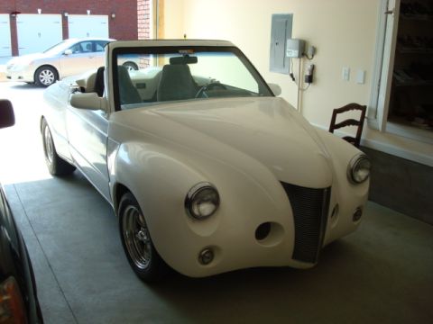 2004 Ford Crown Victoria - Custom convertible car with a unique front end design, parked indoors.