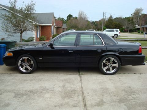 2004 Ford Crown Victoria - Side view of a black 2004 Ford Crown Victoria sedan with custom chrome wheels.
