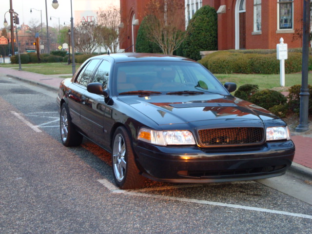 2004 Ford Crown Victoria parked on street with brick building in background