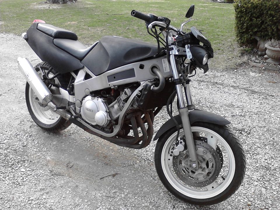 Yamaha motorcycle with black seat and fairings, silver frame, and white wheels