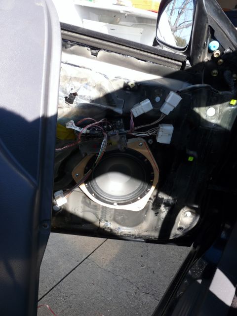 2006 Ford E350 - The interior of a car door is exposed, revealing the speaker and its wiring harness.