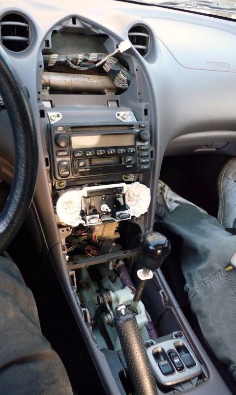 2006 Ford E350 - The interior of a car is shown with the dashboard partially disassembled, revealing the radio and various wires.