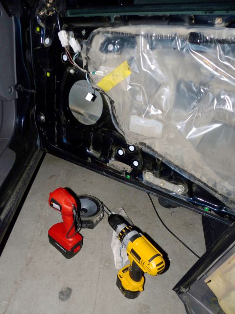 2006 Ford E350 - Tools are laid out next to a car's open door, ready for speaker replacement.