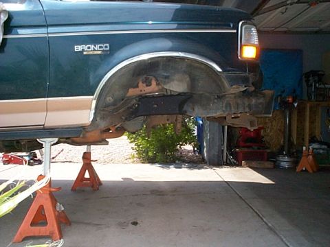 1994 Ford Bronco - 1994 Ford Bronco on jack stands, showing the front fender and wheel well area.