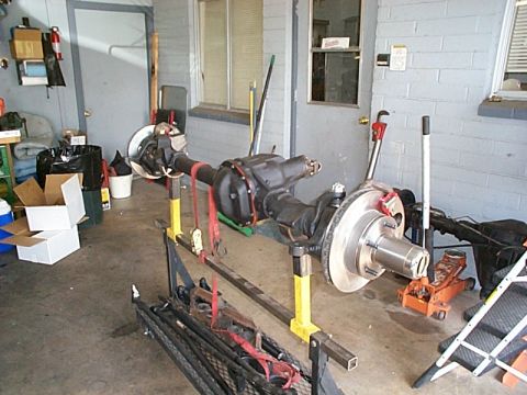 1994 Ford Bronco - A Dana 44 axle assembly is shown on stands in a garage setting.