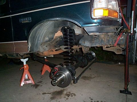 1994 Ford Bronco - The front suspension of a 1994 Ford Bronco is disassembled and supported by jack stands.