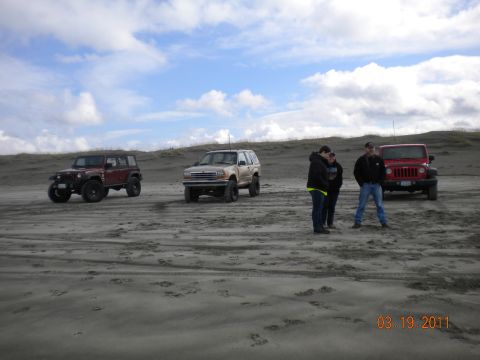 2005 Jeep Wrangler - Four-wheel drive vehicles gathered on a sandy terrain with dunes in the background.