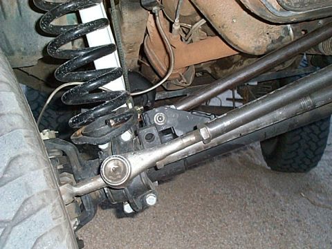 1994 Ford Bronco - Undercarriage view showing the front suspension and steering components, including a coil spring and shock absorber.