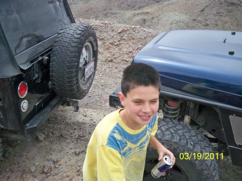 1992 Jeep Wrangler - Two Jeep Wranglers are parked off-road with a boy standing between them.