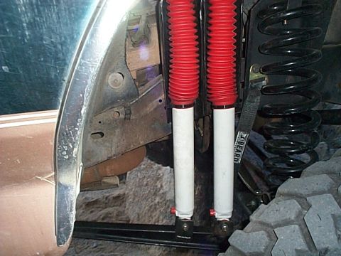 1994 Ford Bronco - Two shock absorbers and a coil spring are visible in this close-up view of suspension parts.