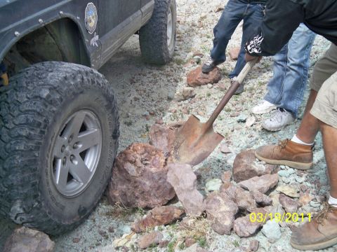 1992 Jeep Wrangler - People digging out a 1992 Jeep Wrangler stuck on rocks.
