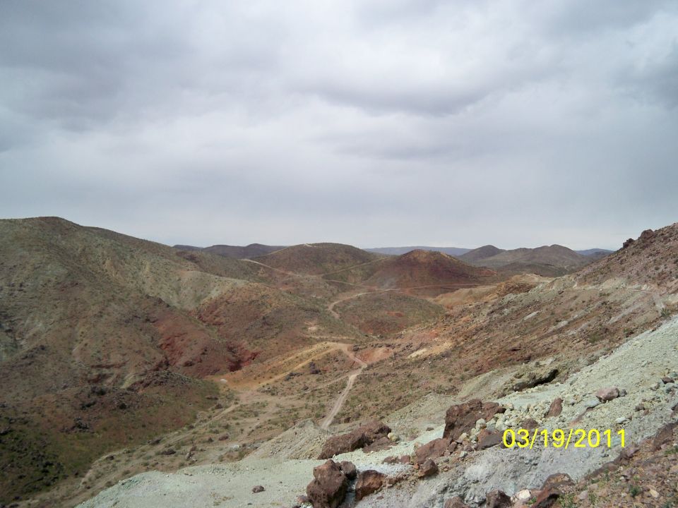 Desert hills with a winding dirt road under a cloudy sky. Date stamp reads 03/19/2011
