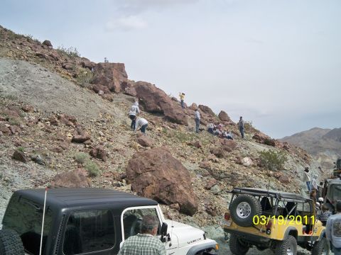 1992 Jeep Wrangler - Multiple Jeep Wranglers are parked on a rocky terrain with people gathered on the hillside.