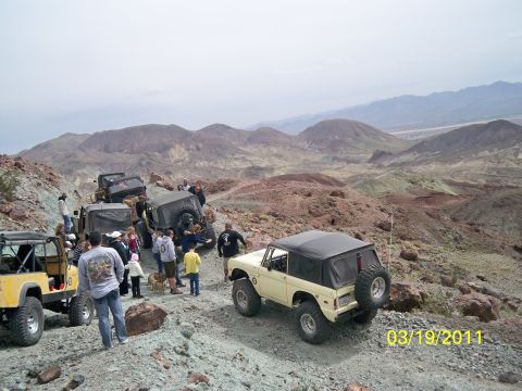 1992 Jeep Wrangler - Group of off-road vehicles and people on a trail in a desert landscape.