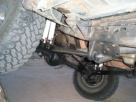 1994 Ford Bronco - Close-up view of the undercarriage, focusing on the suspension and axle modifications of an off-road vehicle.