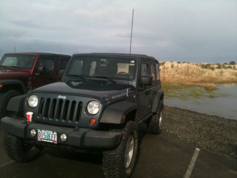 2005 Jeep Wrangler - Two Jeep Wranglers are parked outdoors near a body of water under a cloudy sky.